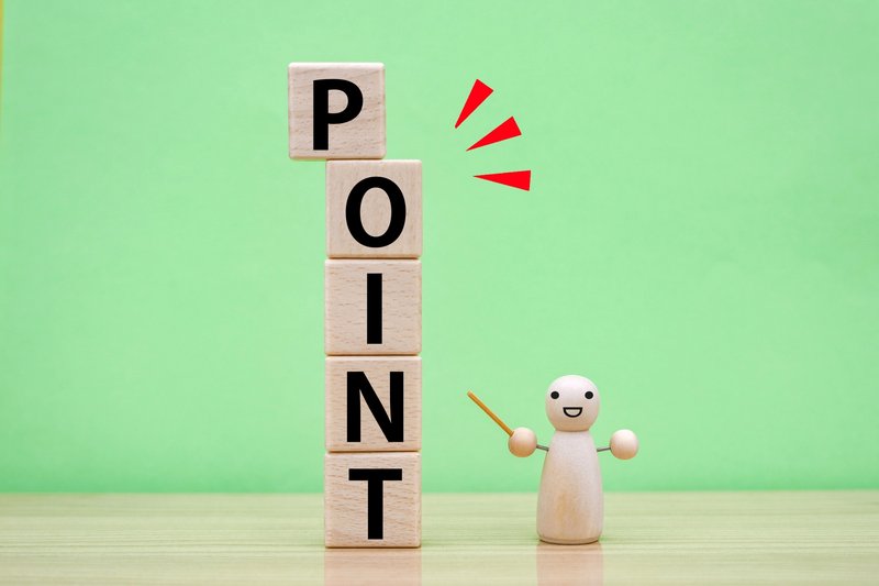 POINTの文字が書かれた積み木と指し棒を持つ木の人形が並んだコンセプト写真